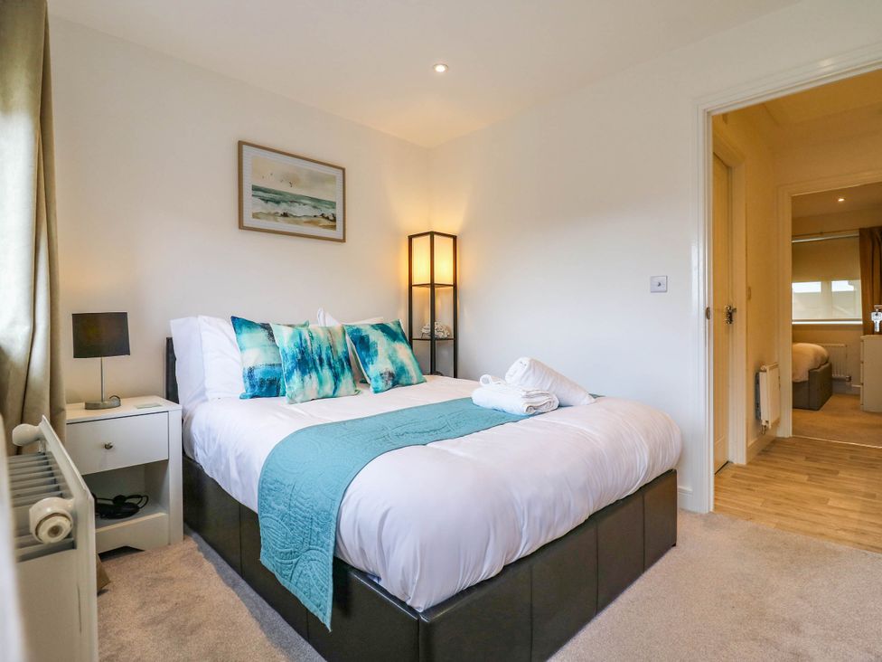 A bedroom with a bed and bedside table at Serenity House