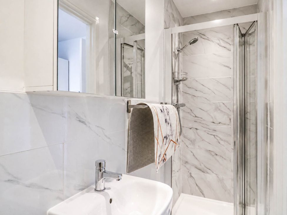 A bathroom with a shower and wash basin at Serenity House
