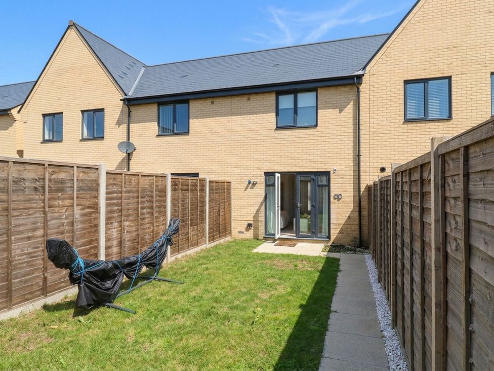 A backyard with grass and a fence at Serenity House