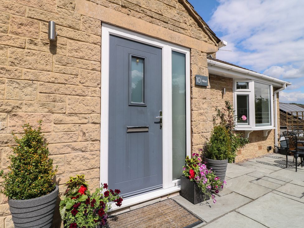 An entrance with a grey door and flower pots at Hillset View in Bakewell