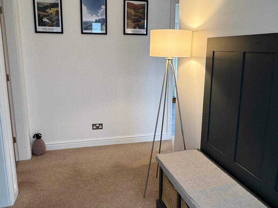A hallway with a lamp and a storage bench at Hillset View in Bakewell