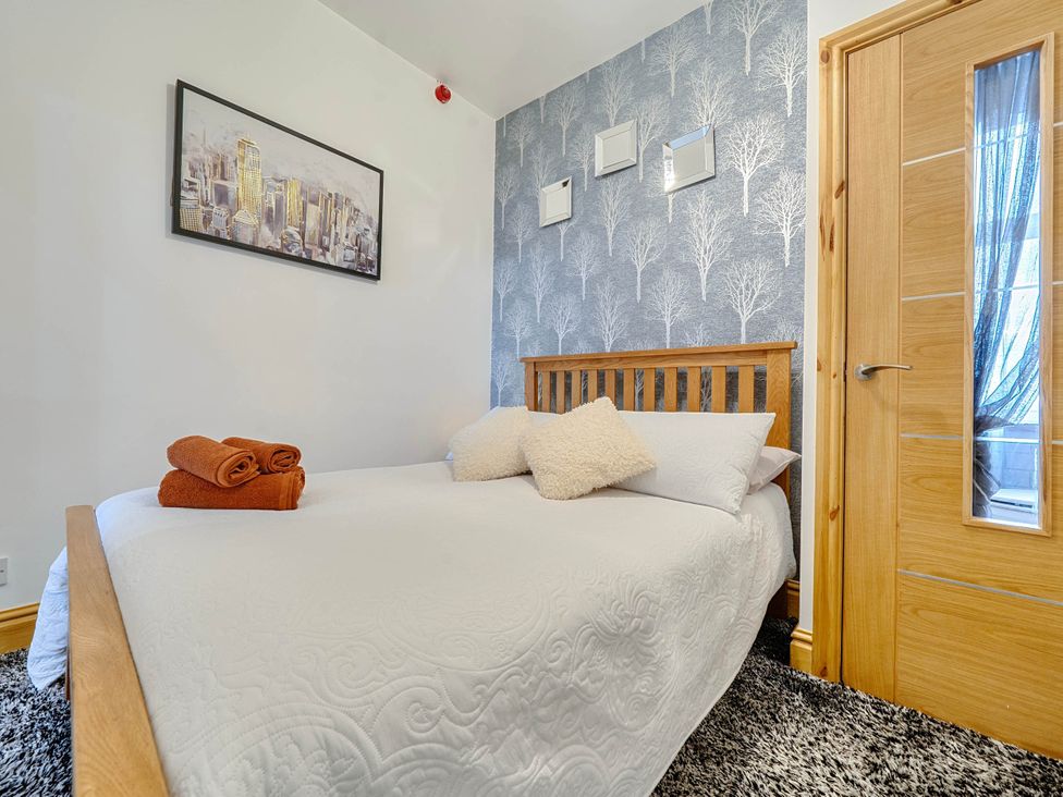 A bedroom with a bed and towels at The Old Barn in Bispham