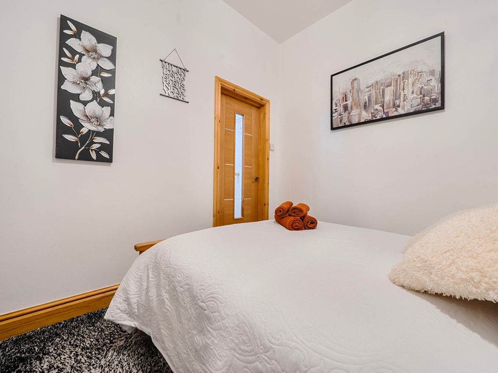 A bedroom with a bed and towels at The Old Barn in Bispham