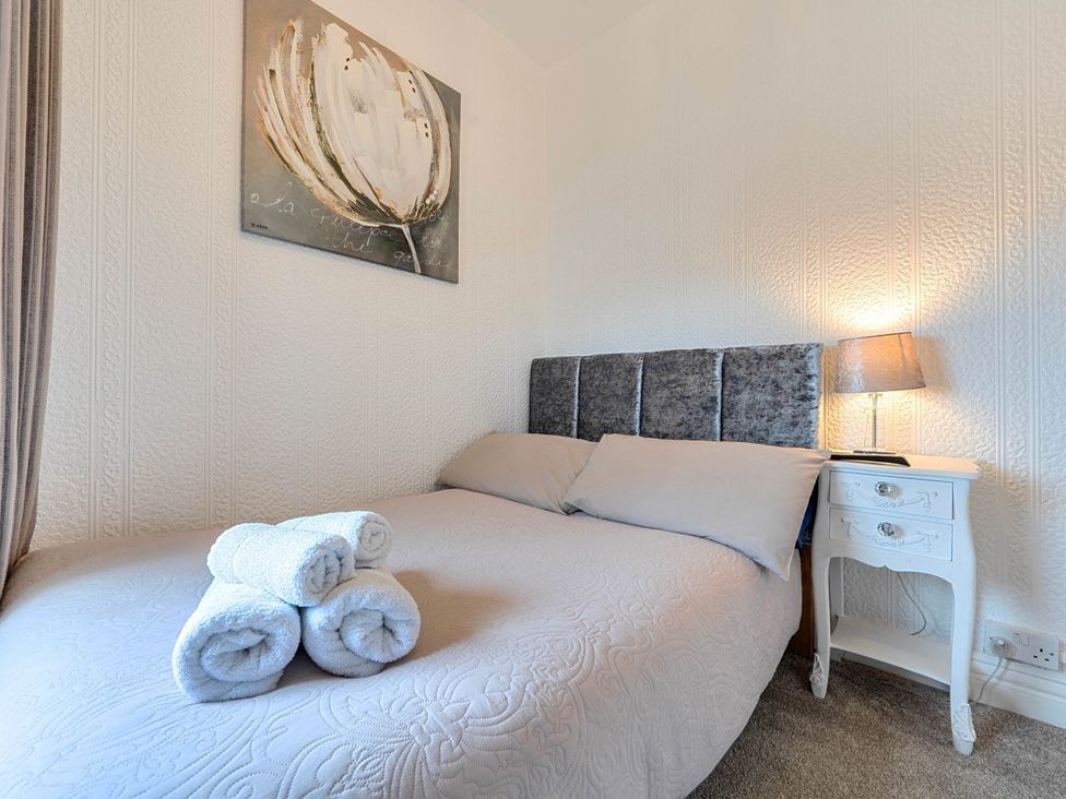 A bedroom with a bed and towels on the blanket at The Old Barn in Bispham