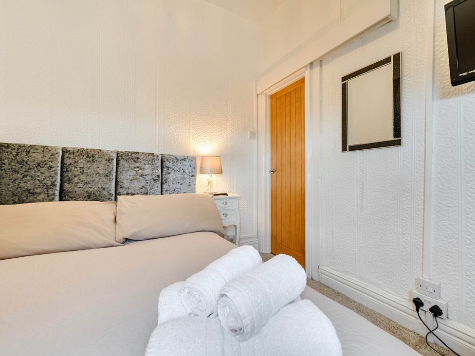 A bedroom with a bed and nightstand at The Old Barn in Bispham