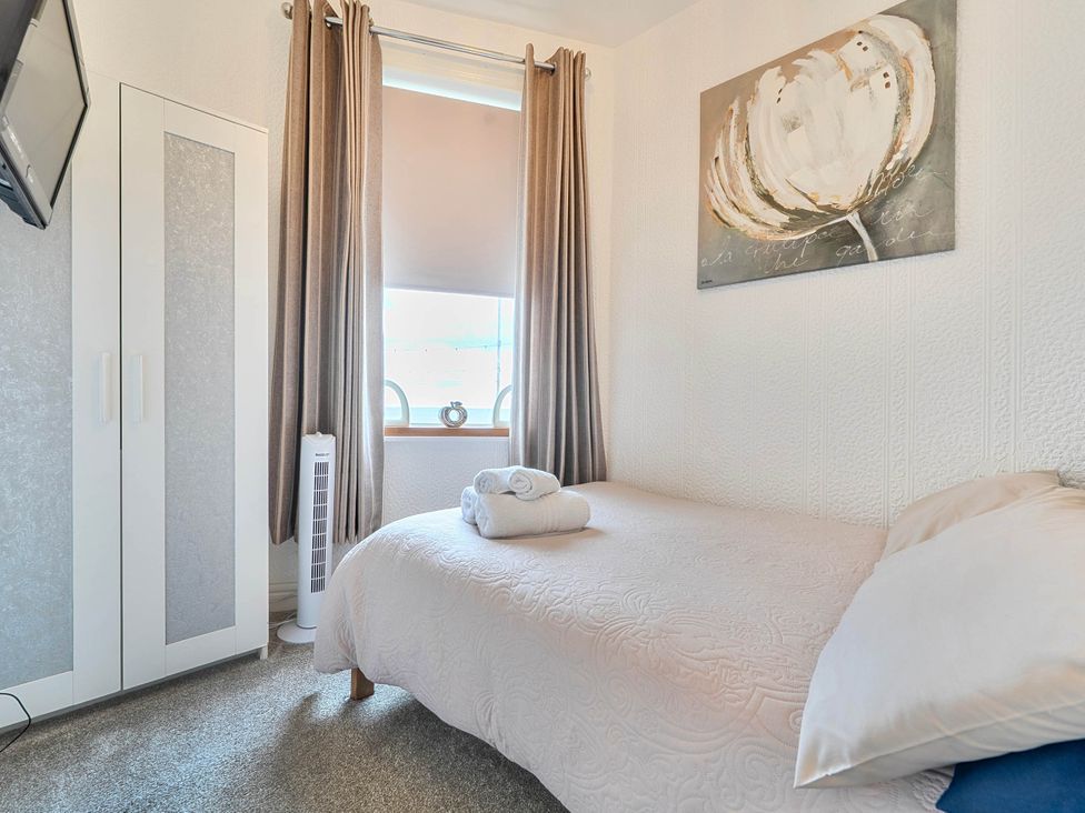 A bedroom with a bed and wardrobe at The Old Barn in Bispham