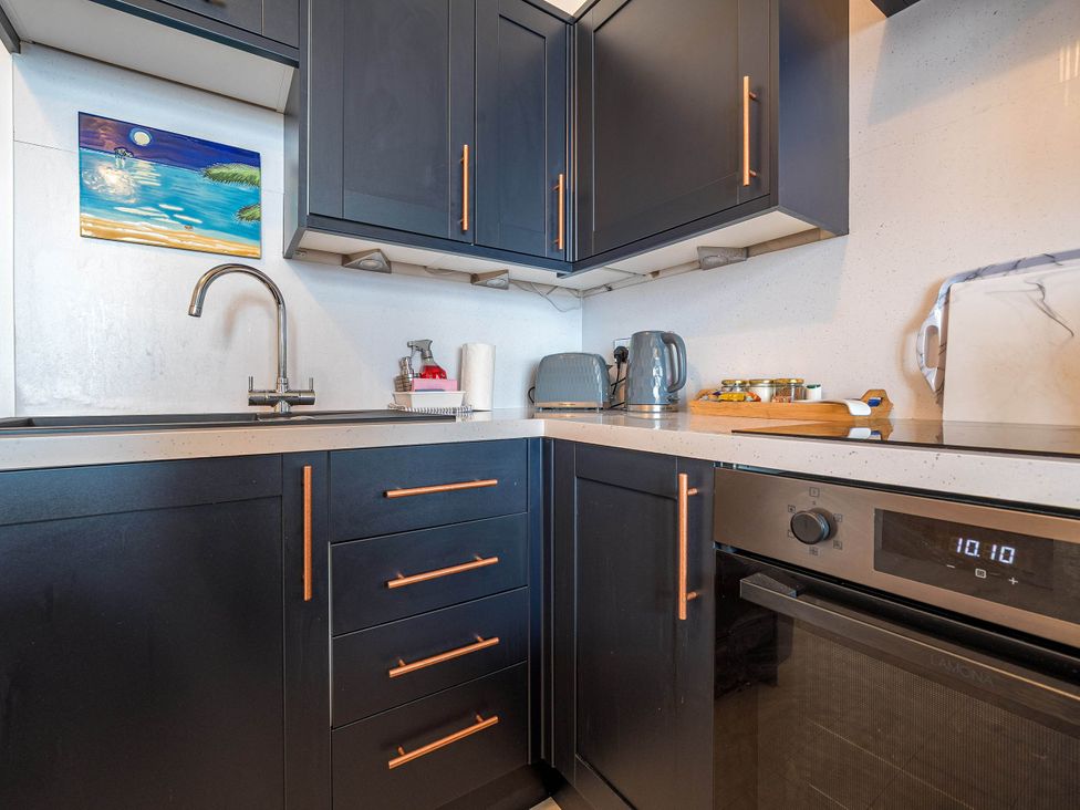 A kitchen with appliances and cabinets at Ground Floor 1Bed Apartment at SeaCote Bispham