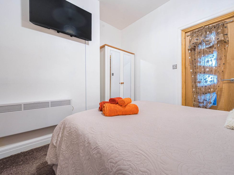 A bedroom with a bed and television at Ground Floor 1Bed Apartment at SeaCote Bispham