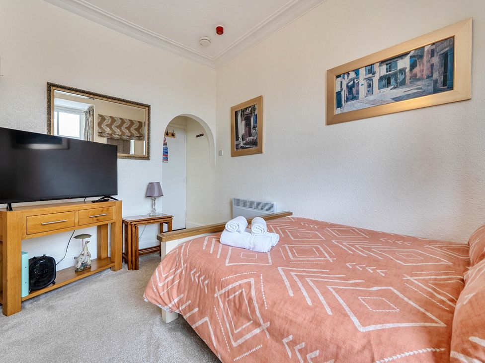 A bedroom with a bed and television at Ground Floor Studio Apartment at SeaCote in Bispham