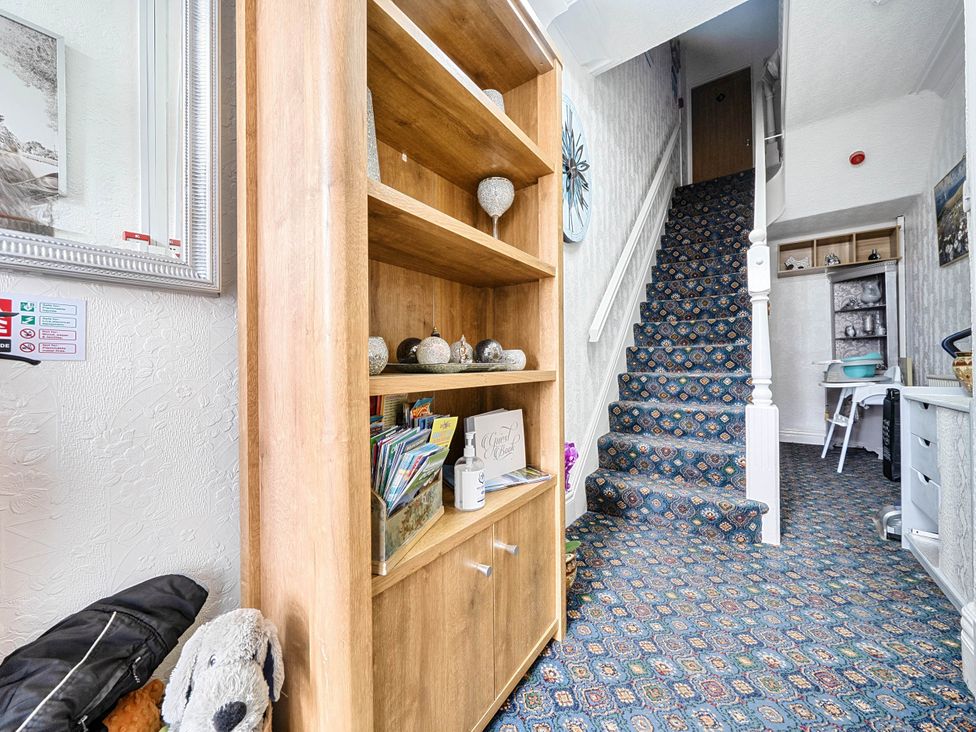 A hallway with a staircase and a bookshelf at the Ground Floor Studio Apartment at SeaCote in Bispham