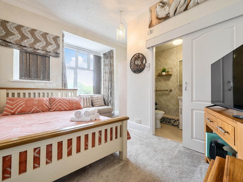 A bedroom with a bed and television at Ground Floor Studio Apartment at SeaCote Bispham