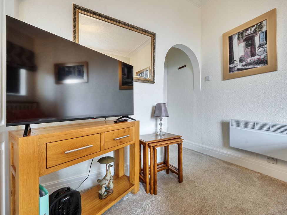 A living room with a television and side tables at Ground Floor Studio Apartment at SeaCote in Bispham