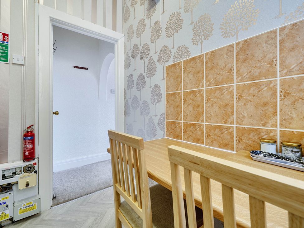 A dining area with table and chairs at Ground Floor Studio Apartment at SeaCote in Bispham