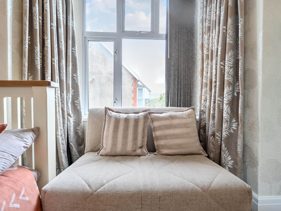 A living room with a sofa and pillows at Ground Floor Studio Apartment at SeaCote in Bispham