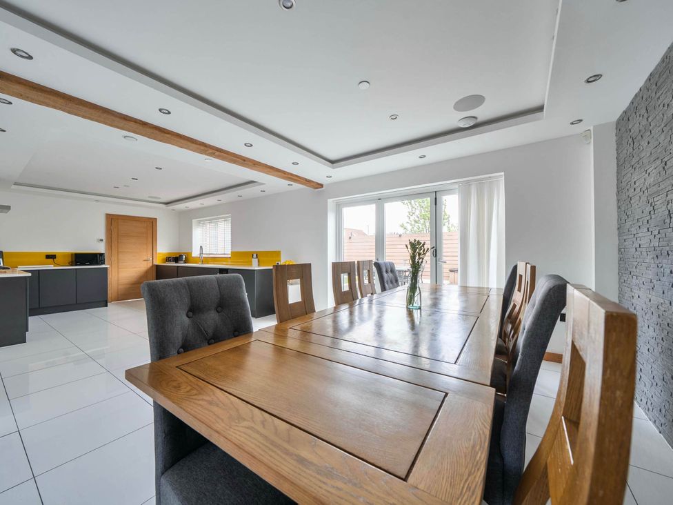 A dining room with a table and chairs at a property in Abergele