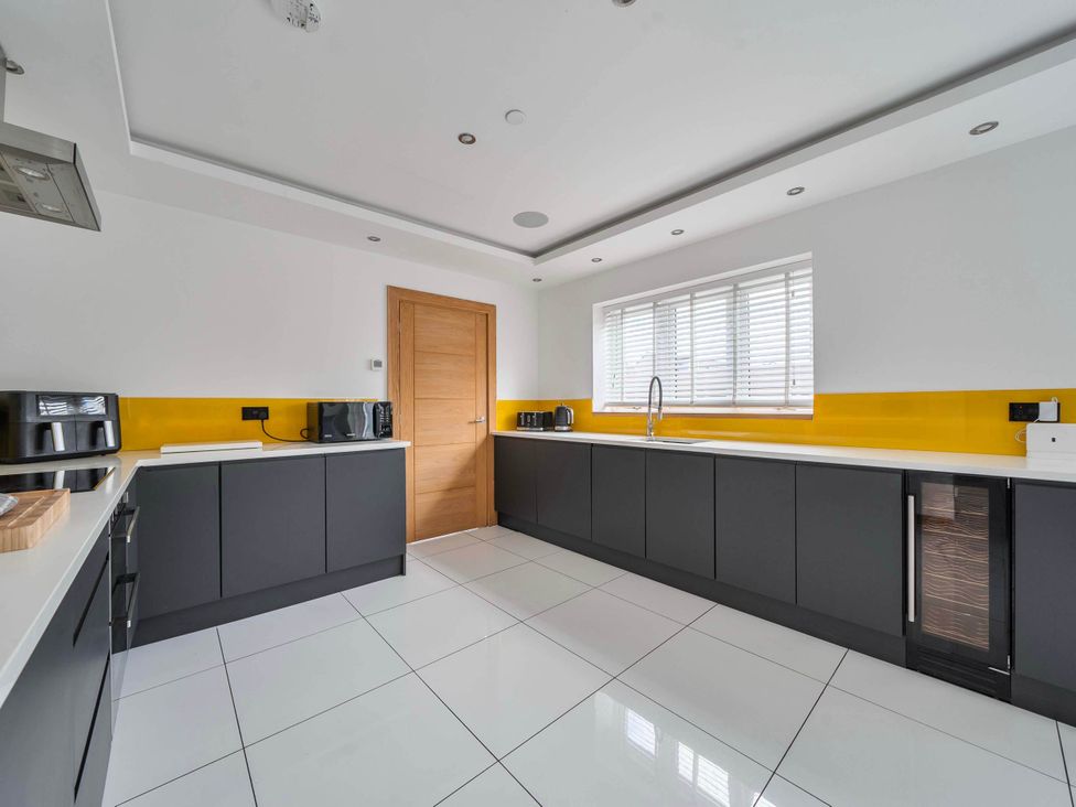 A kitchen with appliances and a window at The Old Barn in Abergele