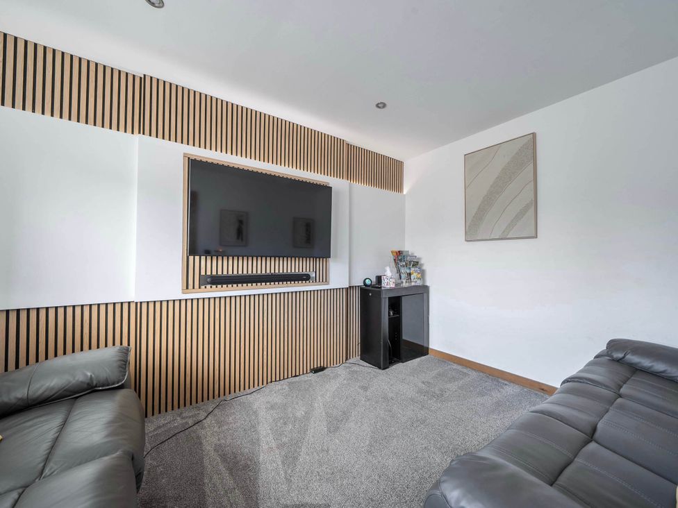 A living room with a television and a sofa at the property in Abergele