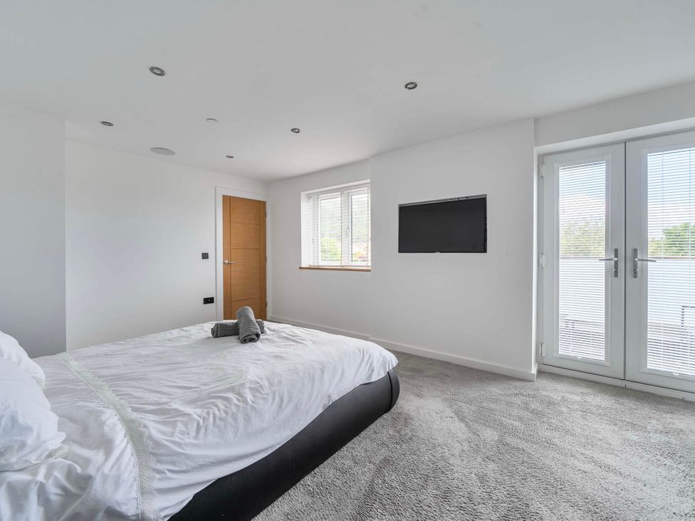 A bedroom with a bed and television at Abergele