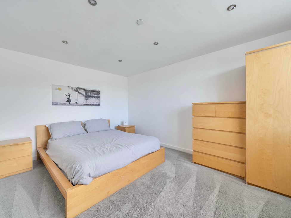 A bedroom with a bed and dresser at The Old Barn in Abergele