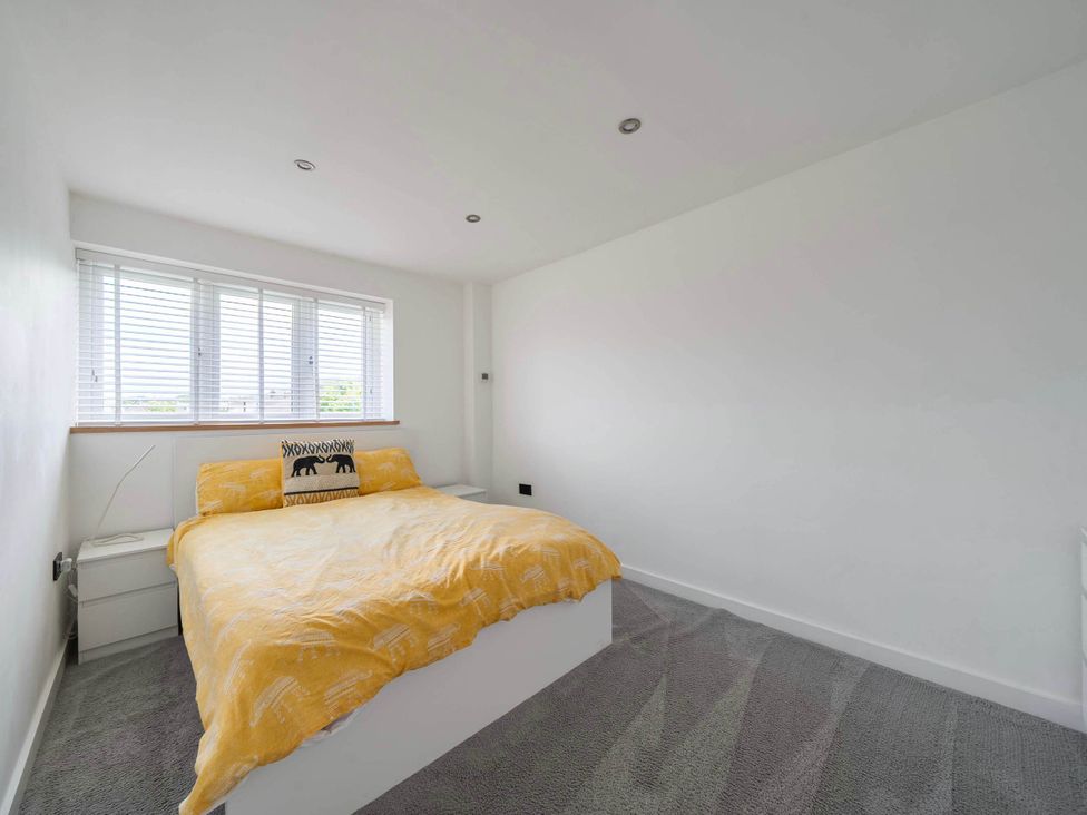 A bedroom with a bed and bedside table at The Old Barn in Abergele