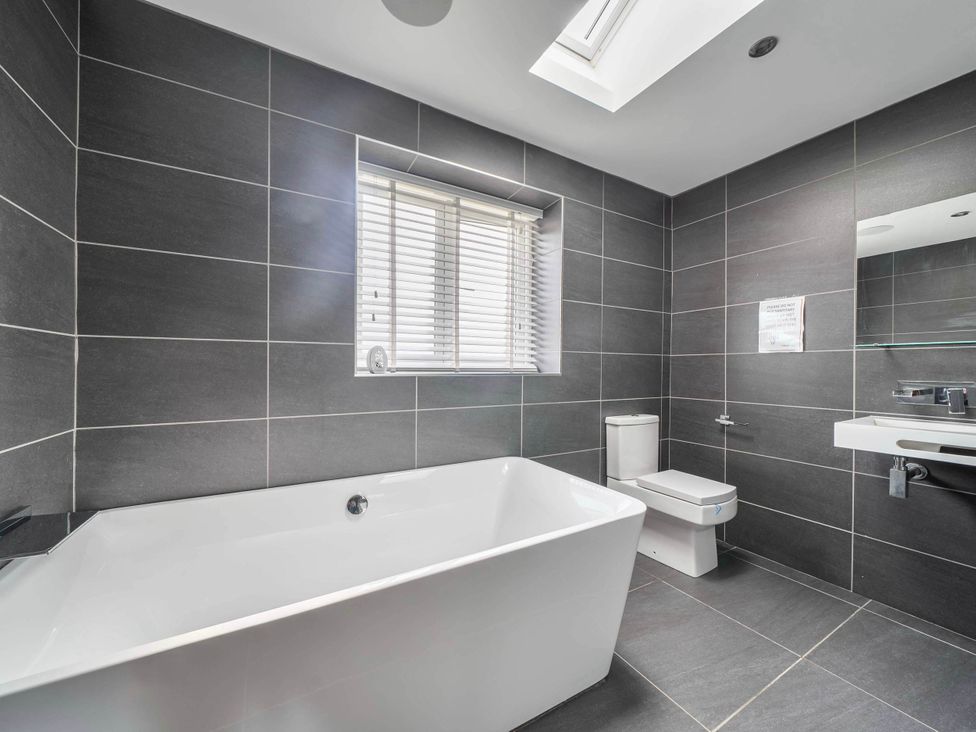 A bathroom with a bath tub and toilet at The Old Barn in Abergele