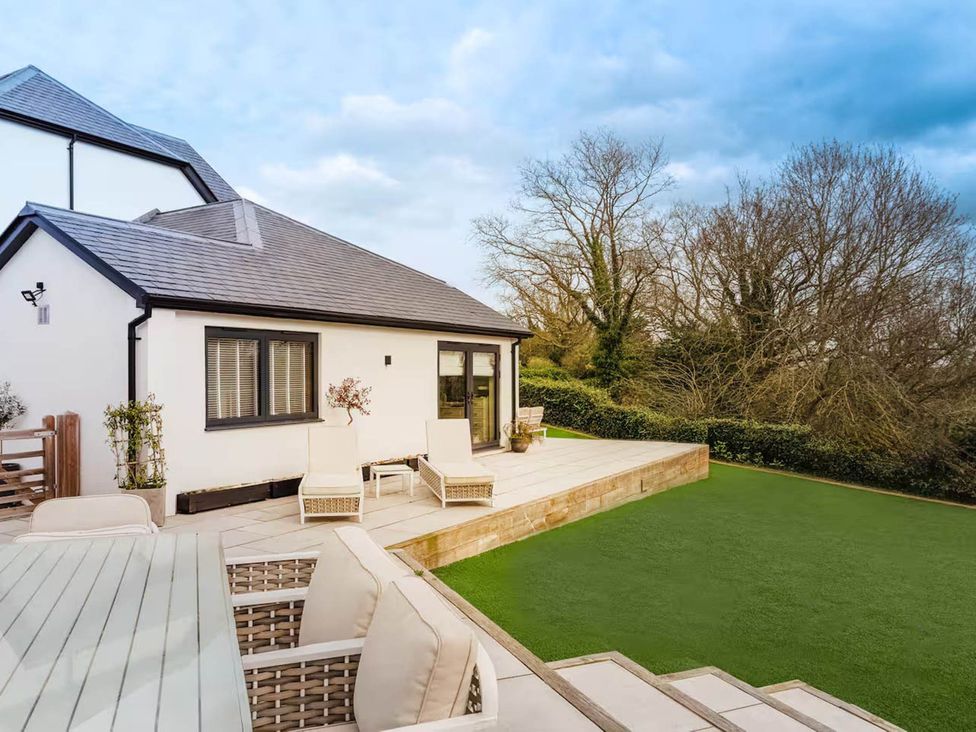 An outdoor view of a house with a deck and lawn at Rochester Retreat Spacious 5 Bedroom House in Higham
