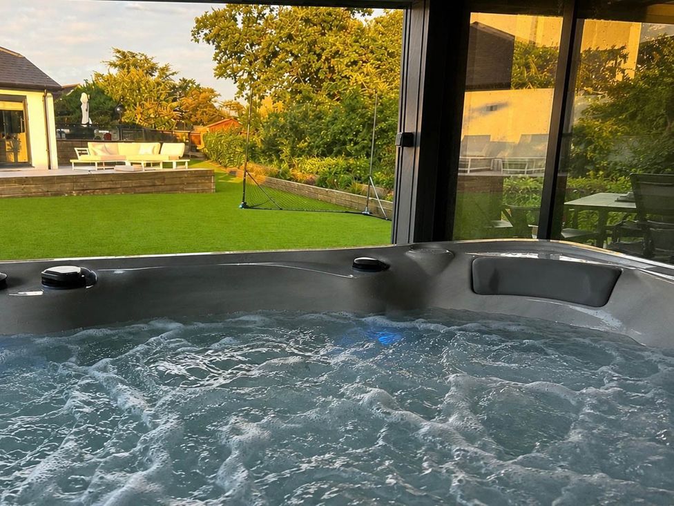 A hot tub with a view of the garden at Rochester Retreat Spacious 5 Bedroom House in Higham