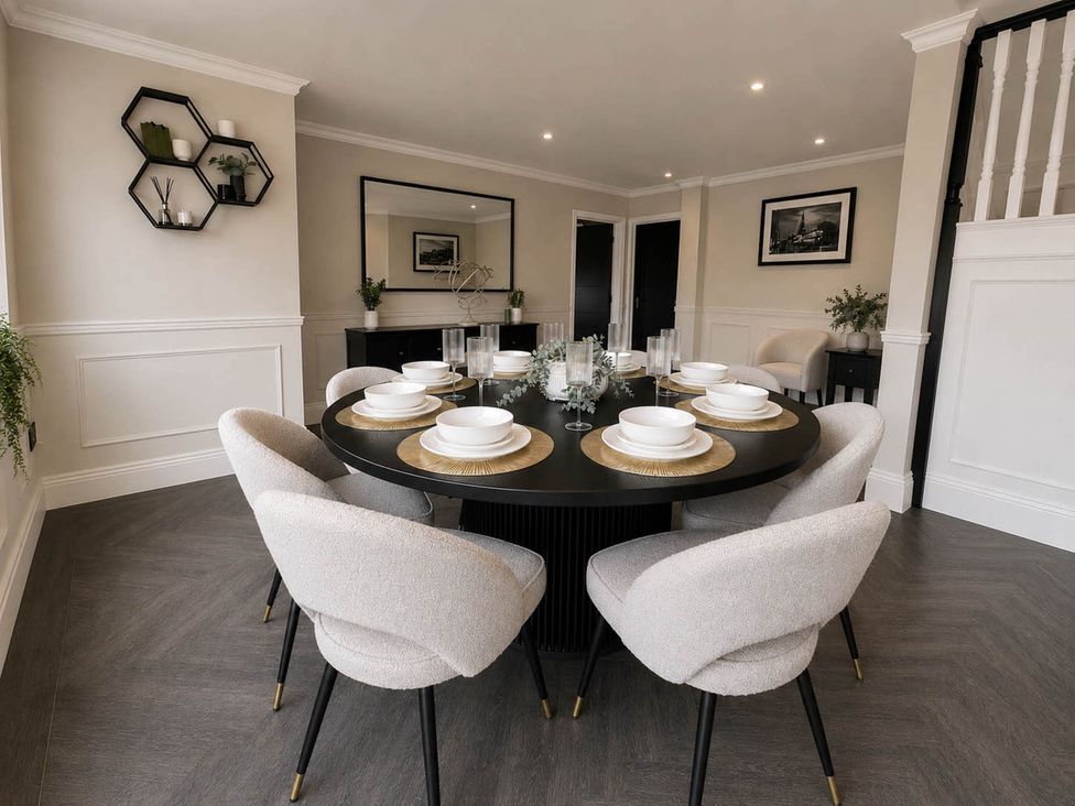 A dining room with a round table set for a meal at Rochester Retreat Spacious 5 Bedroom House in Higham