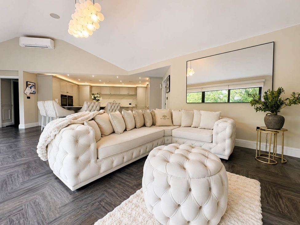 A living room with a white sofa and mirror at Rochester Retreat Spacious 5 Bedroom House in Higham