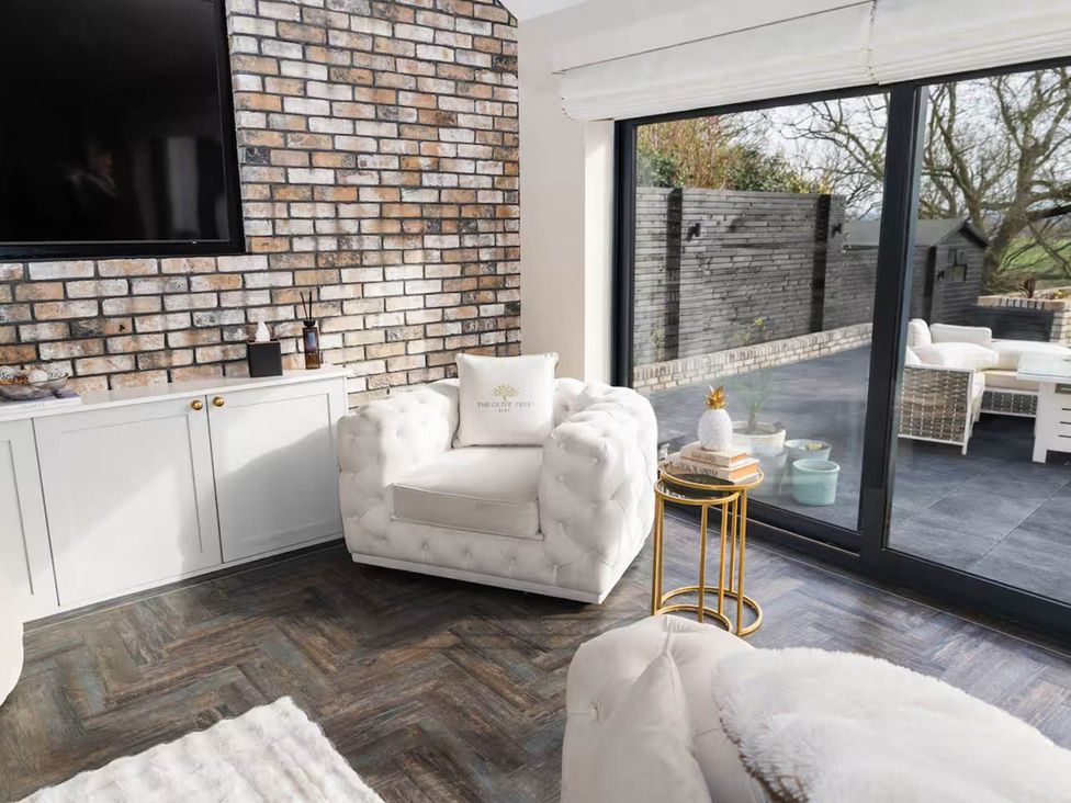 A living room with a television and an armchair at Rochester Retreat Spacious 5 Bedroom House in Higham