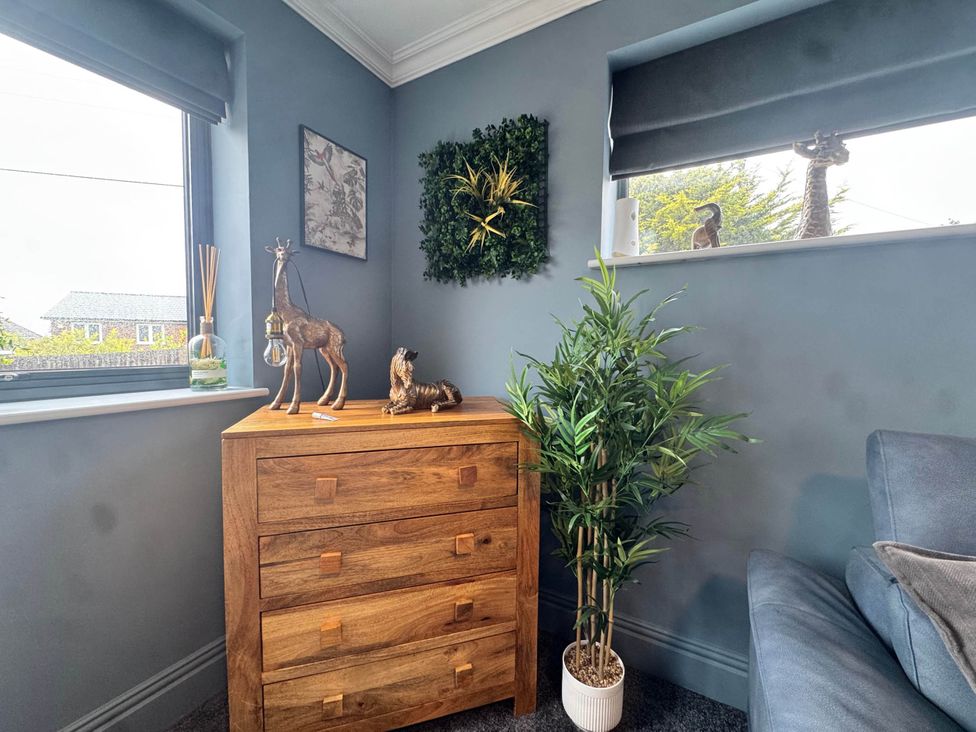 A snug with wooden chest of drawers and decorative plants at Rochester Retreat Spacious 5 Bedroom House in Higham