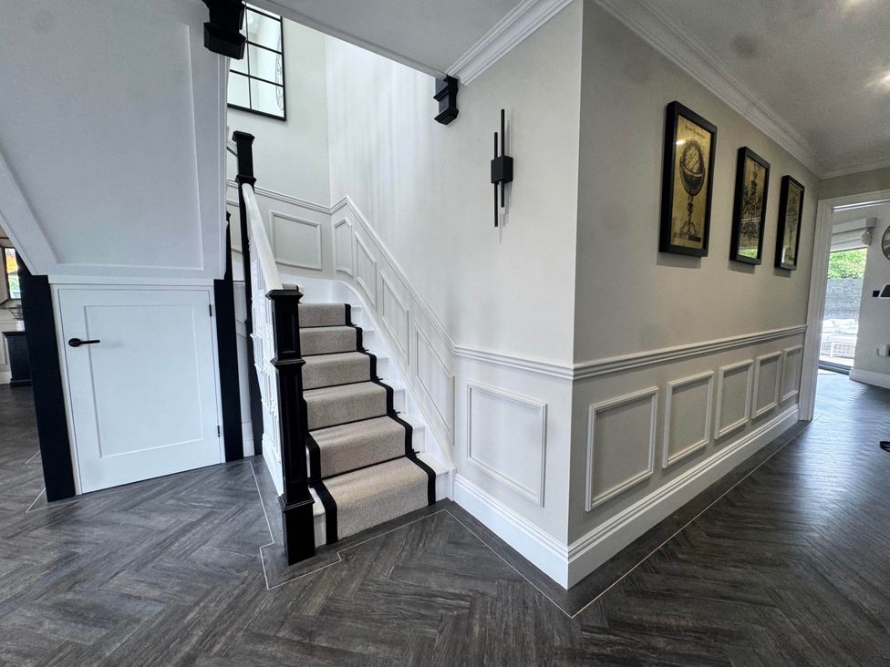 A hallway with a staircase and wall art at Rochester Retreat Spacious 5 Bedroom House in Higham