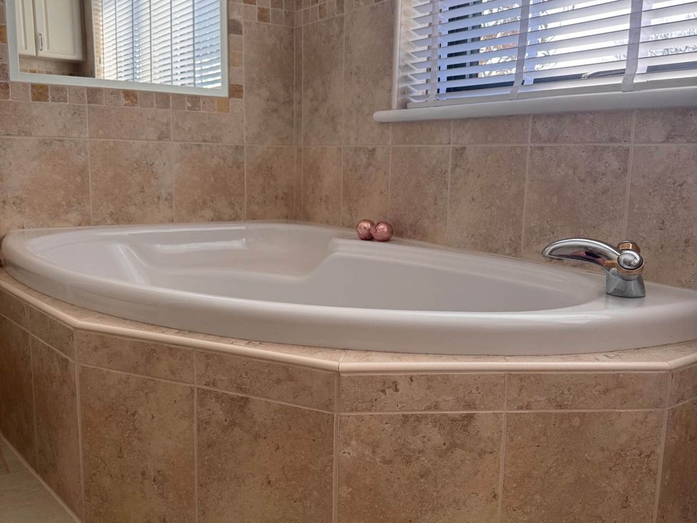 A bathtub and faucet in a bathroom at Rochester Retreat Spacious 5 Bedroom House Higham