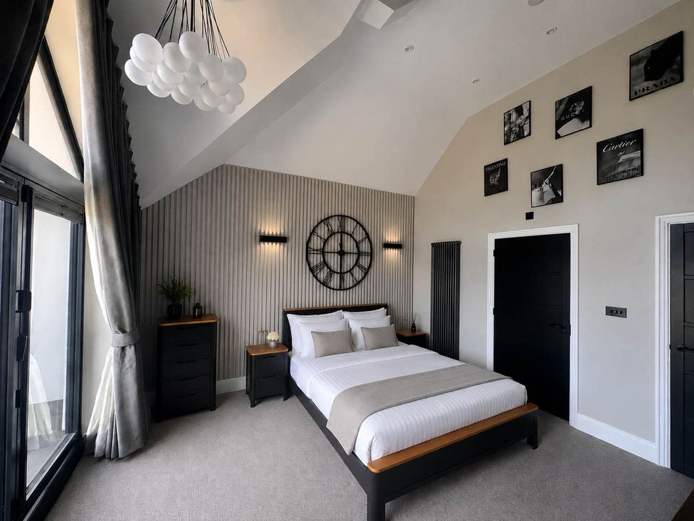 A bedroom with a bed and nightstand at Rochester Retreat Spacious 5 Bedroom House in Higham