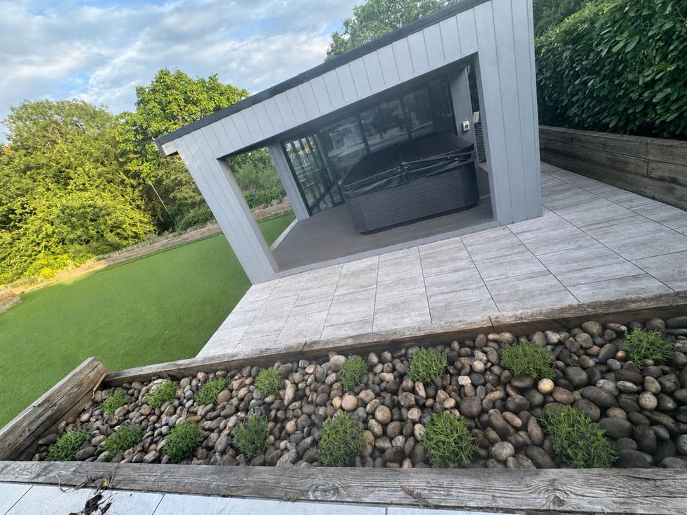A garden with a hot tub and landscaped area at Rochester Retreat Spacious 5 Bedroom House in Higham