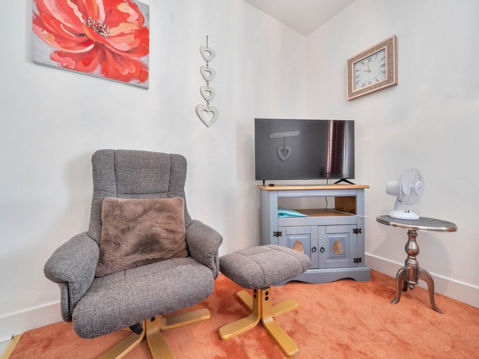 A living room with a chair and television at the property