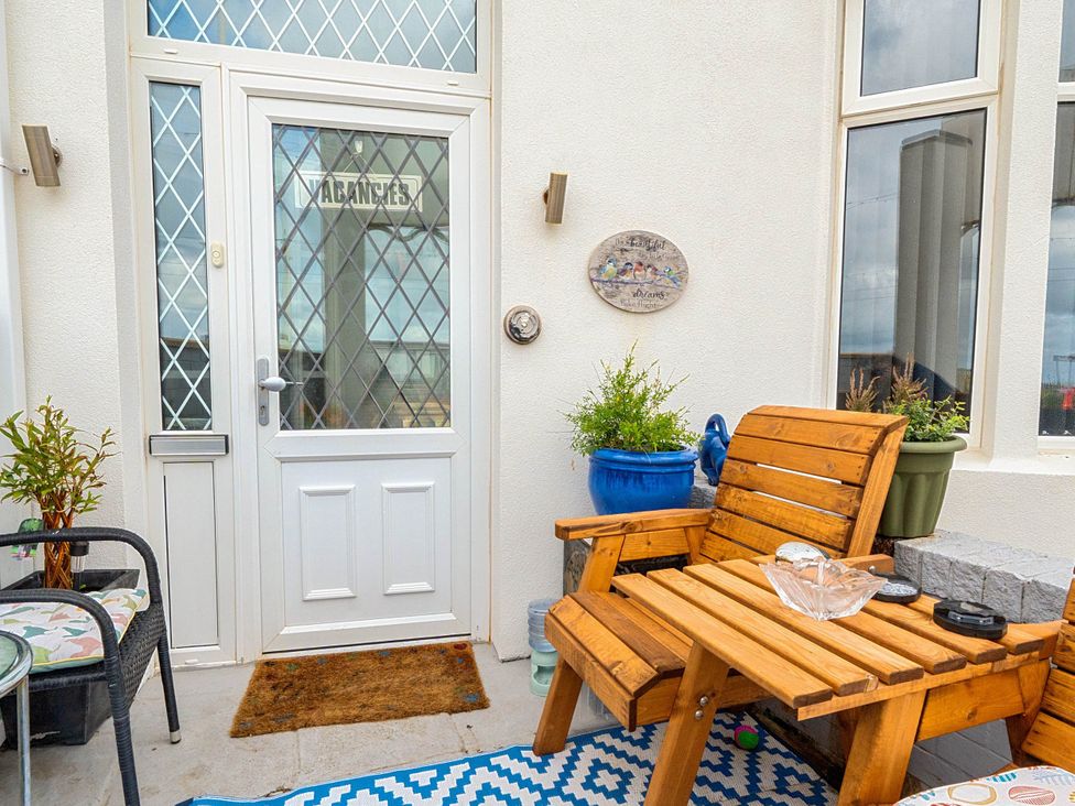 An outdoor seating area with a wooden chair and a table at a property
