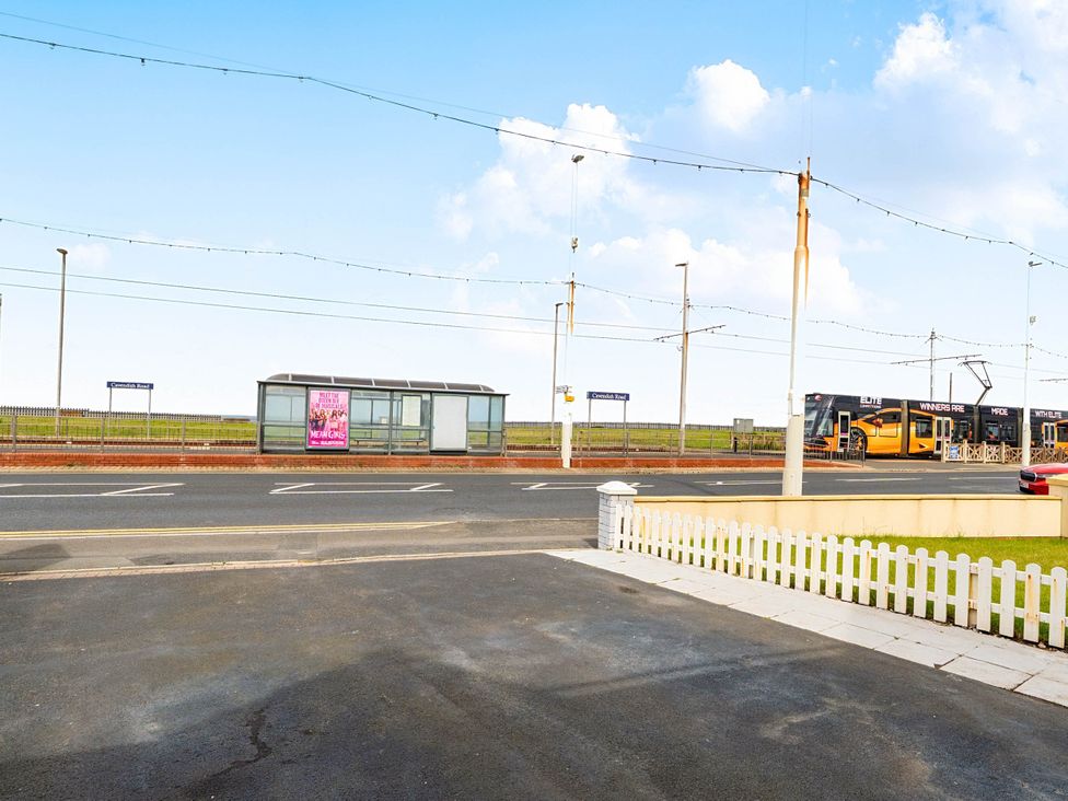 A bus stop and tram on a road at an outdoor location