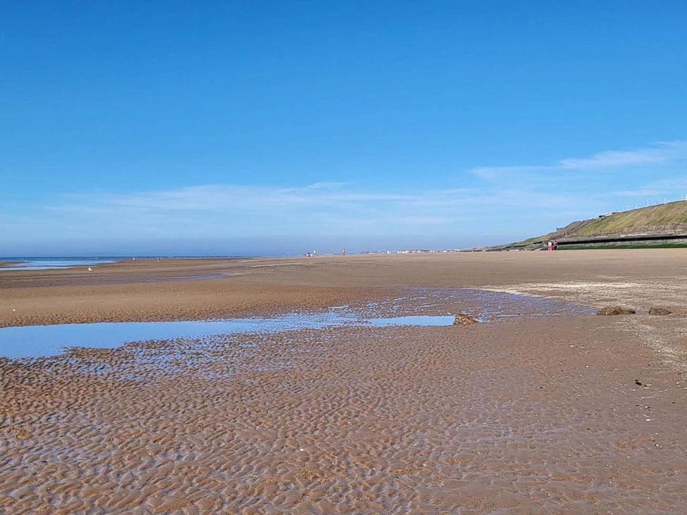 A beach with sand and water under a clear sky