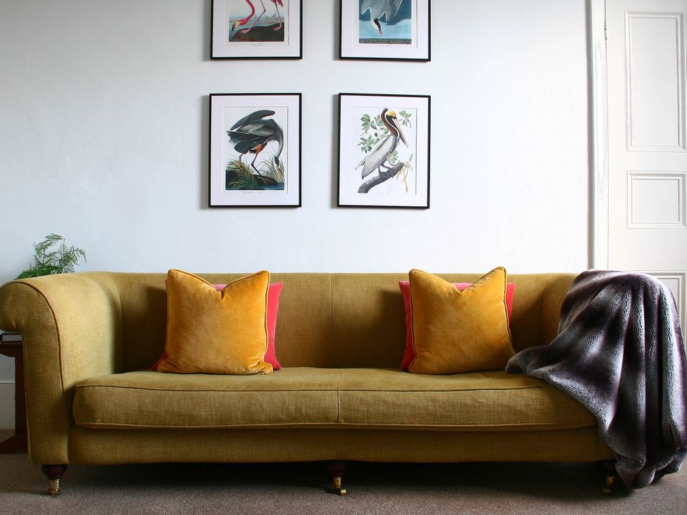 A sofa with cushions and wall art at Beautiful 6Bed Sleeps 12 Stunning Views in Lynton