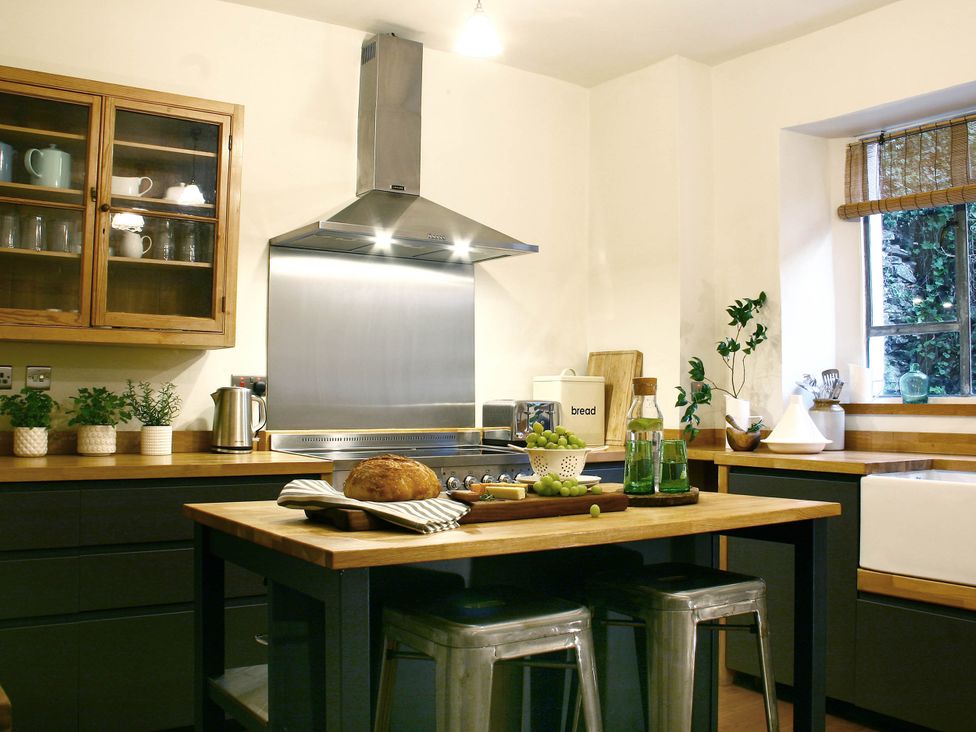 A kitchen with a wooden table and stainless steel hood at Beautiful 6Bed Sleeps 12 Stunning Views in Lynton