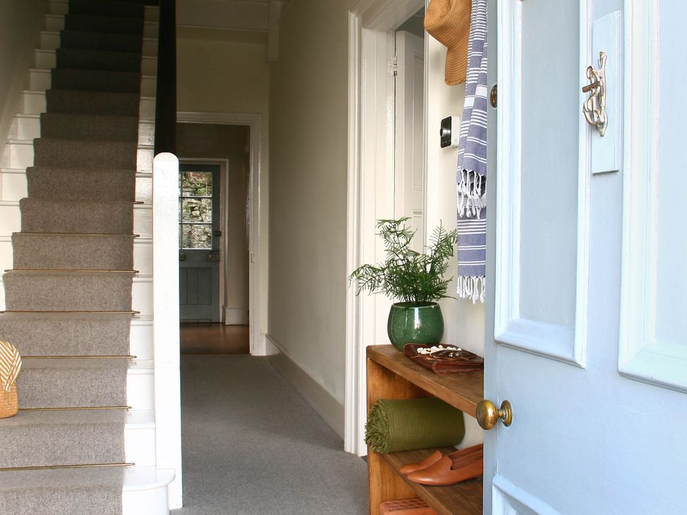 A hallway with stairs and a shelf at Beautiful 6Bed Sleeps 12 Stunning Views in Lynton