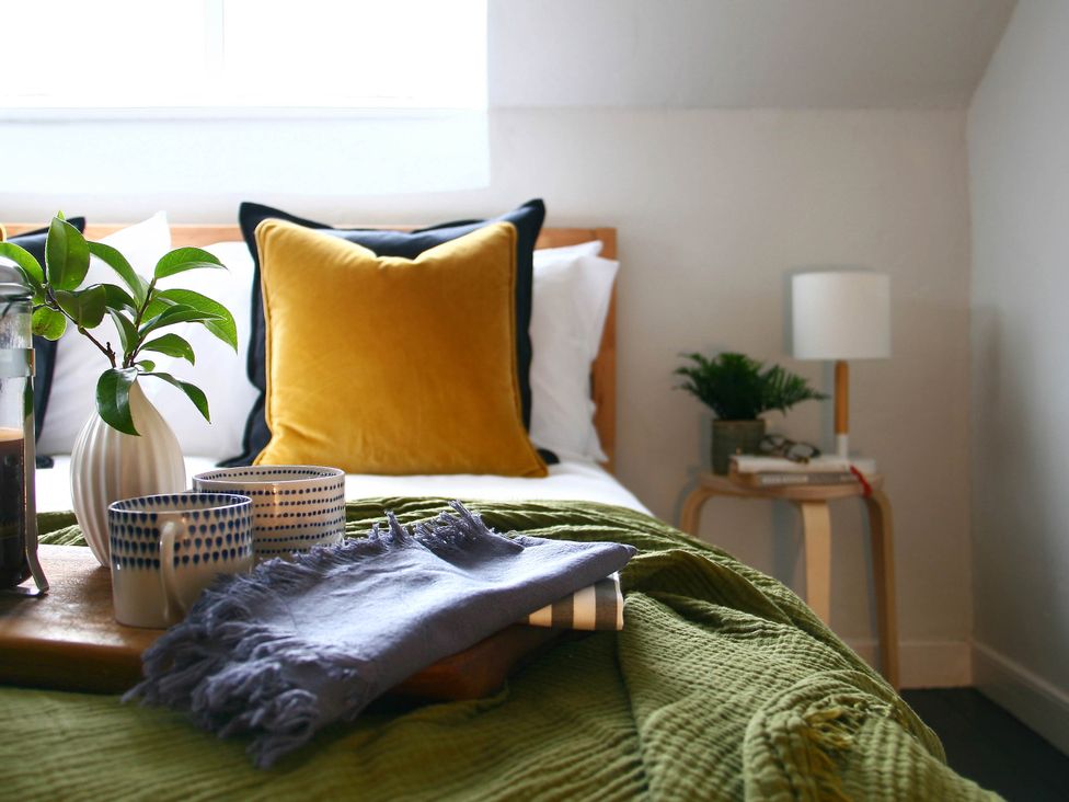 A bedroom with a bed, pillows, plant, and cups at Beautiful 6Bed Sleeps 12 Stunning Views, Lynton