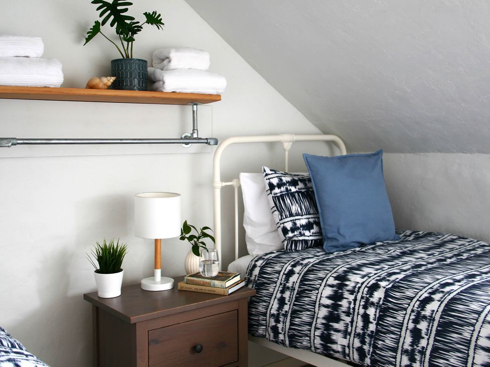 A bedroom with a bed, nightstand, and shelf at Beautiful 6Bed Sleeps 12 Stunning Views in Lynton