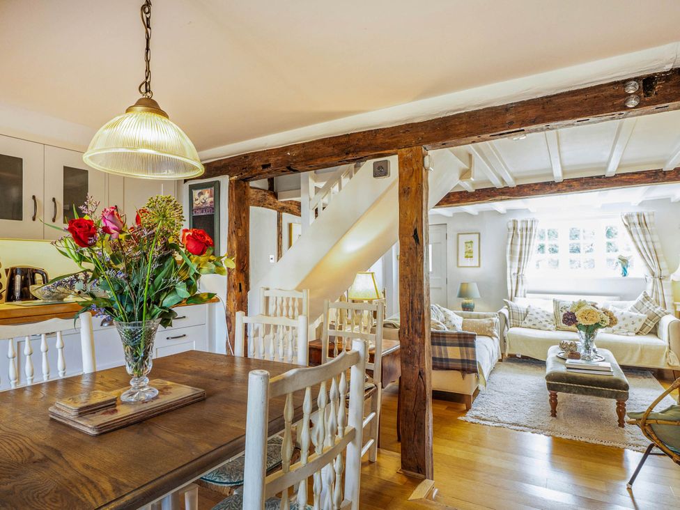A living room with a dining area and staircase at Cottage Sleeps 4 with Enclosed Garden in Turville near Henley-On-Thames