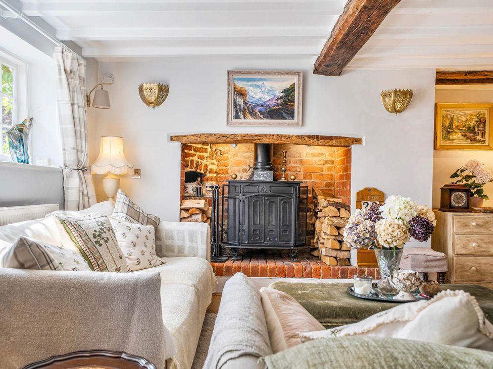 A living room with a fireplace and decorative items at Cottage Sleeps 4 with Enclosed Garden Turville near Henley-On-Thames