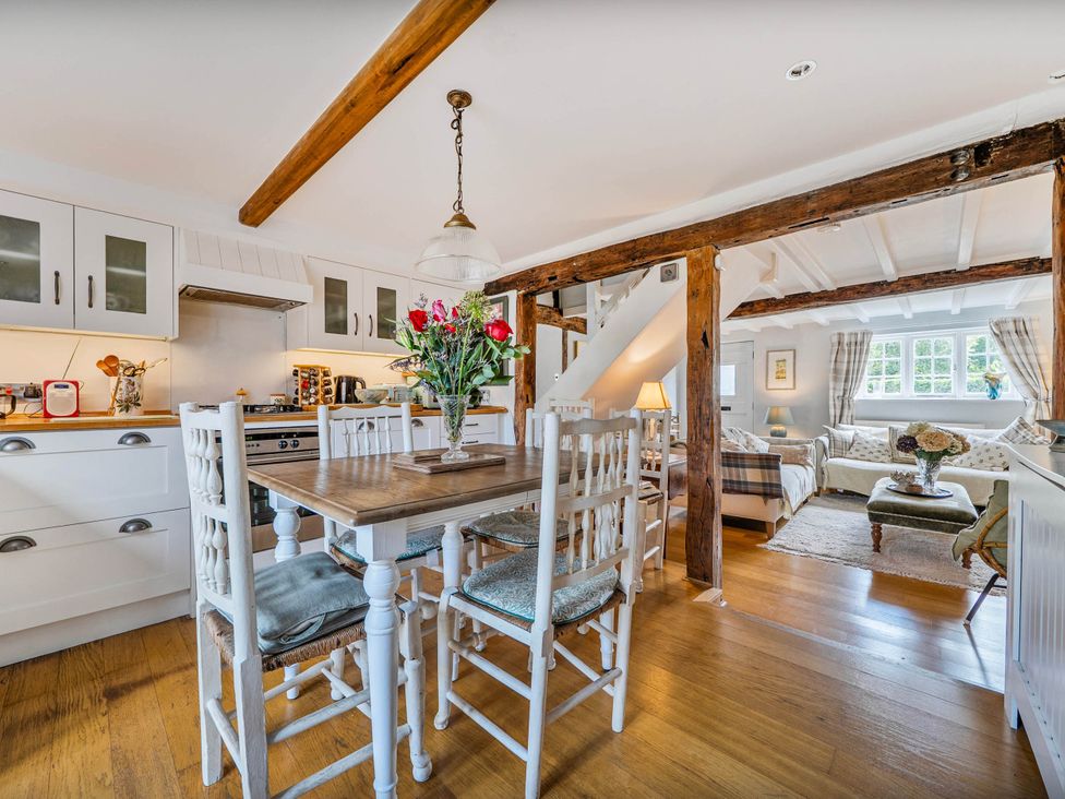 A kitchen and dining area with a wooden table and chairs at Cottage Sleeps 4 with Enclosed Garden Turville near Henley-On-Thames