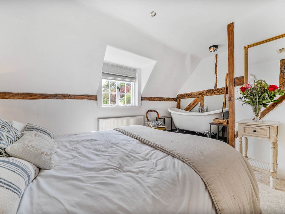 A bedroom with a bed and a bath tub in Cottage Sleeps 4 with Enclosed Garden Turville near Henley-On-Thames