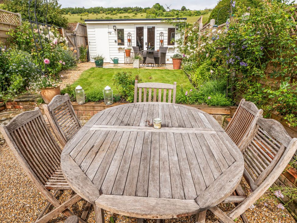 A garden with a wooden table and chairs at Cottage Sleeps 4 with Enclosed Garden in Turville near Henley-On-Thames