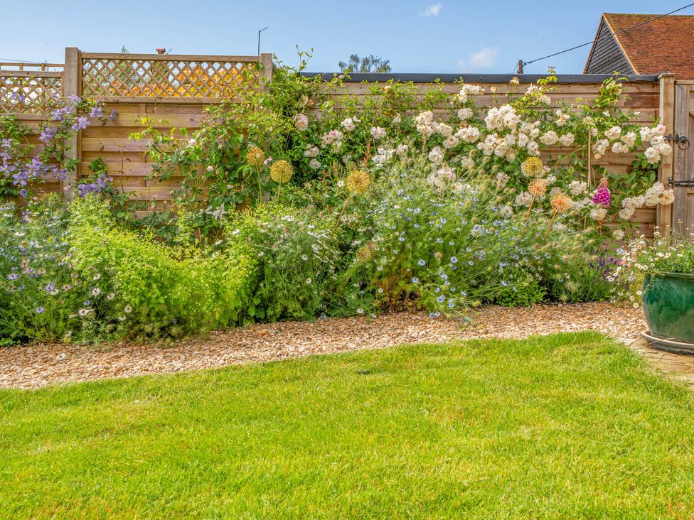 A garden with flowers and a gravel path at Cottage Sleeps 4 with Enclosed Garden in Turville near Henley-On-Thames